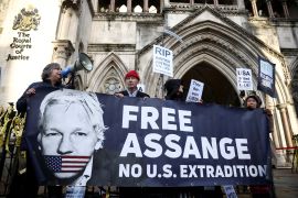 Supporters of Julian Assange display signs and a banner, outside the Royal Courts of Justice in London on December 10, 2021 [File: Reuters/Henry Nicholls]