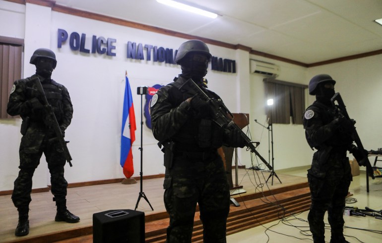 Members of the Haitian National Police stand guard during a news conference