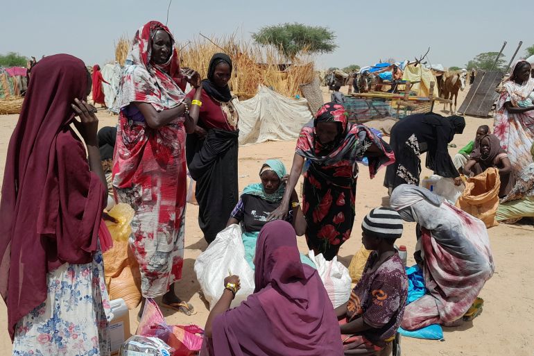 Sudanese refugees who have fled the violence in their country gather to receive food supplements from World Food Programme (WFP), near the border between Sudan and Chad.