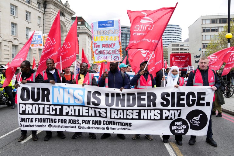 Nurses on strike carry a banner in London on May 1