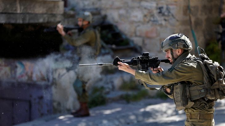 An Israeli soldier shoots rubber bullets at Palestinians in Hebron in the Israeli-occupied West Bank [
