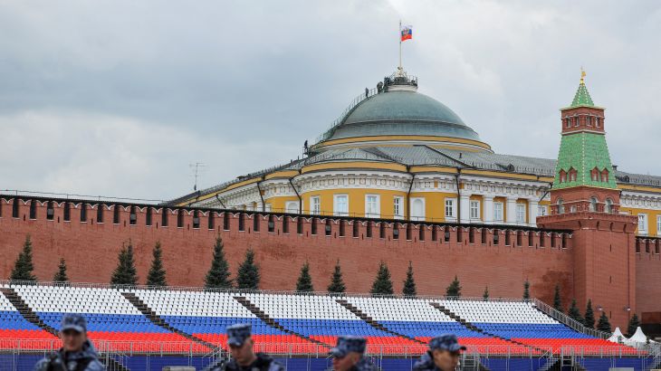 Russian law enforcement officers stand guard in Red Square, with people seen on the dome of the Kremlin Senate building in the background, in central Moscow, Russia, May 3, 2023.