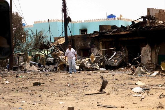 A man walks near damaged buildings at the central market during clashes between the paramilitary Rapid Support Forces and the army in Khartoum North