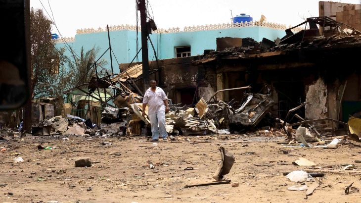 A man walks near damaged buildings at the central market during clashes between the paramilitary Rapid Support Forces and the army in Khartoum North