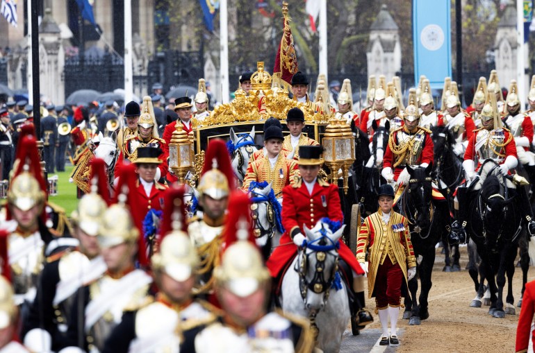 Britain's King Charles and Queen Camilla travel in the Diamond Jubilee State Coach from Buckingham Palace to Westminster Abbey. Their coach is surrounded by dozens of Horse Guards. 
