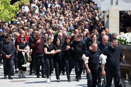 People attend a funeral for the murdered security guard, following a school mass shooting, after a boy opened fire on others, killing fellow students and staff