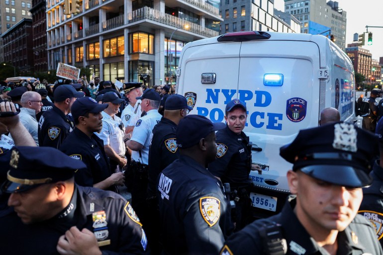 Police and protesters mix together outside of an NYPD van