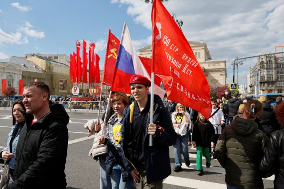 People carrying flags cross a street during celebrations on Victory Day, which marks the 78th anniversary of the victory over Nazi Germany in World War Two, in Moscow, Russia May 9, 2023. REUTERS/Shamil Zhumatov