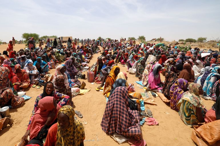 Sudanese refugees, who have fled the violence in their country, wait to receive food rations from World Food Programme