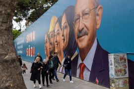 People walk past an election banner of Kemal Kilicdaroglu