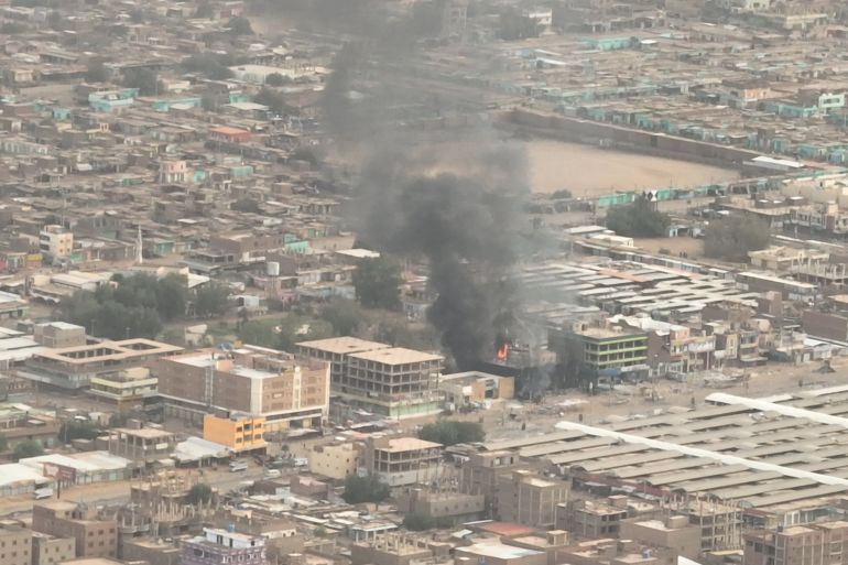 An aerial shot shows smoke rising from a bank in Sudan