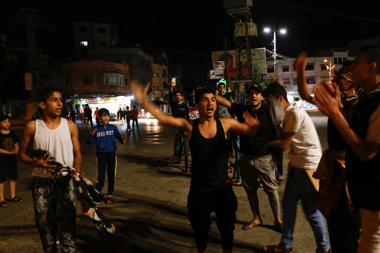 Palestinians celebrate on the street after Palestinian factions and Israel agreed on a ceasefire, in Gaza, May 13, 2023. 