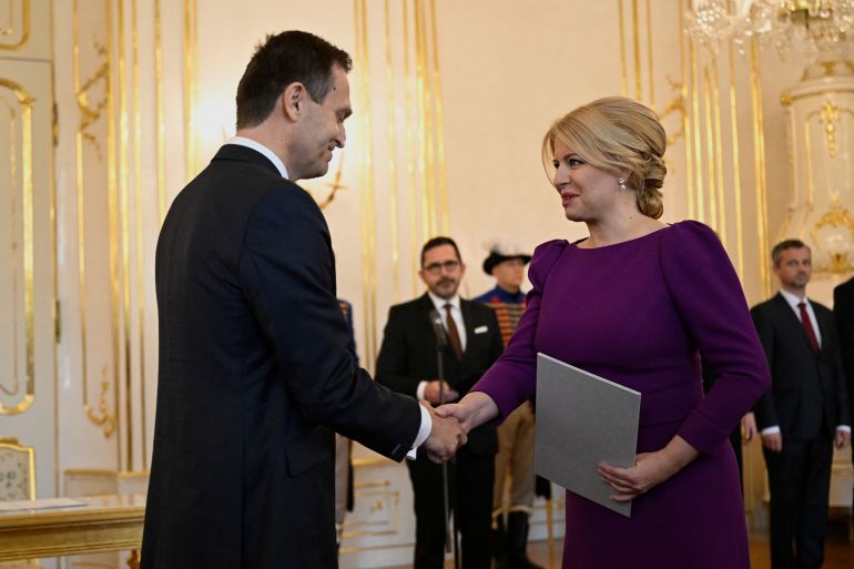 Slovakia's President Zuzana Caputova and Prime Minister Ludovit Odor shake hands after the cabinet's inauguration at the Presidential Palace in Bratislava
