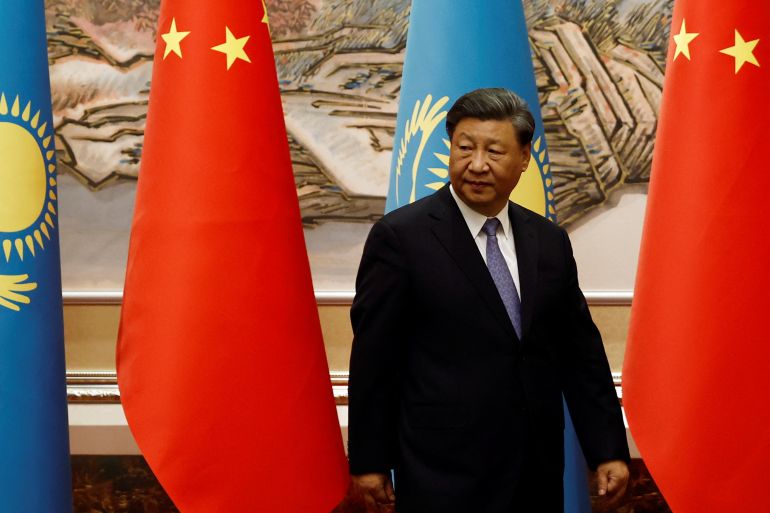 Chinese president Xi Jinping walking in front of Chinese and central Asian flags