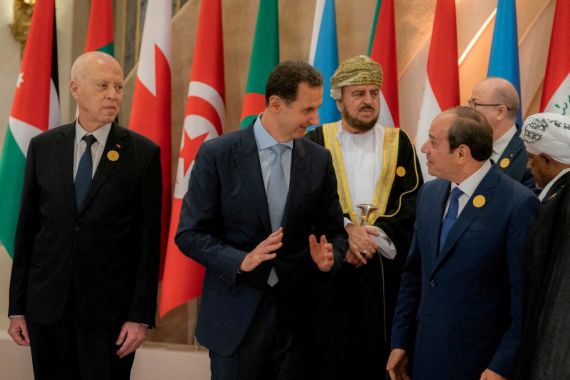Syria's President Bashar al-Assad chats with Egypt's President Abdel Fattah al-Sisi, ahead of the Arab League summit