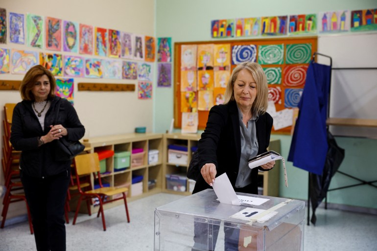 A woman casts her vote at a polling station, during the general election, in Athens