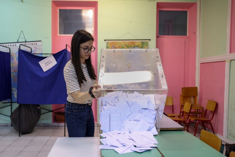 An election worker empties a ballot box at a polling station in Thessaloniki, Greece.