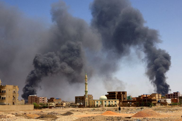 FILE PHOTO: A man walks while smoke rises above buildings after aerial bombardment, during clashes between the paramilitary Rapid Support Forces and the army in Khartoum North, Sudan, May 1, 2023.