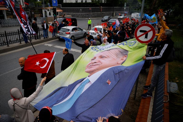 Supporters of Turkish President Tayyip Erdogan carry a banner with his image