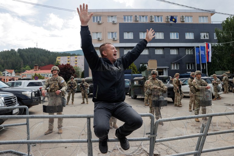 A Kosovo Serb reacts as U.S. KFOR soldiers stand guard in front of the municipality office, in the town of Leposavic, Kosovo, May 29, 2023. 