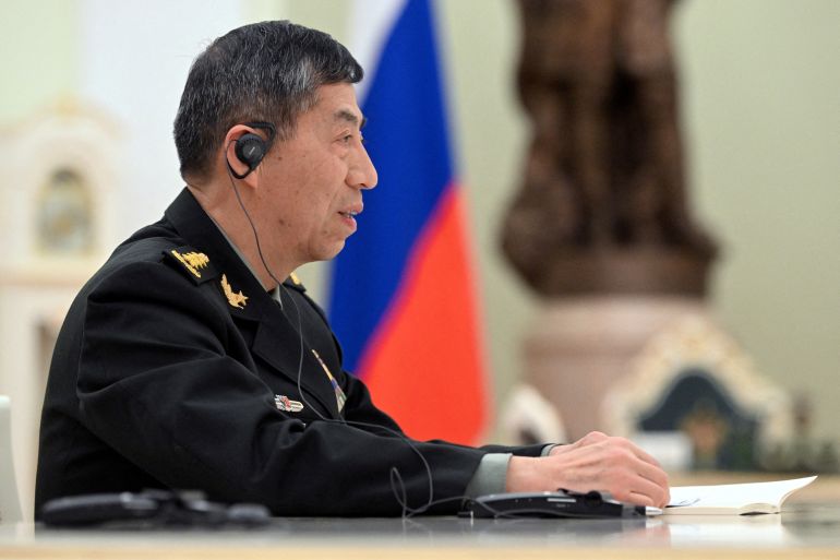 Chinese Defence Minister Li Shangfu at a meeting in Russia. He is wearing a military uniform and headphones for translation.