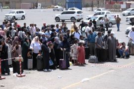 People fleeing war-torn Sudan queue to board a boat from Port Sudan