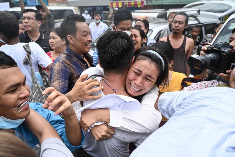 A woman hugs a just-released prisoner outside Insein prison in Yangon. She looks delighted and emotional. Other people around her are also greeting relatives and smiling