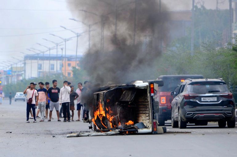 Smoke billows from a vehicle allegedly burned by the Meitei community