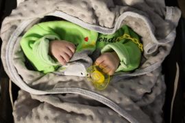 A baby in a crib at the Child Houses centre in rebel-held Idlib which shelters unaccompanied Syrian children and those of unknown parentage. [Omar Haj Kadour/AFP]