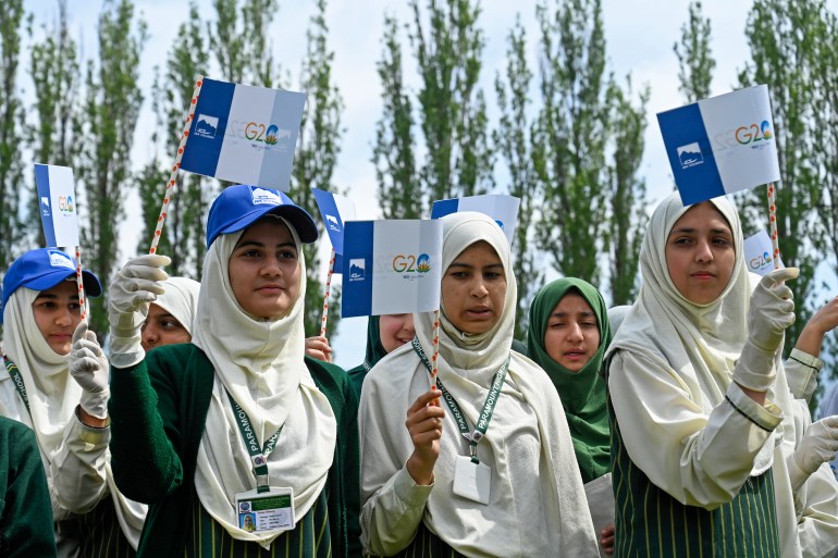 School girls hold G2O flags during a function ahead of the summit in Srinagar