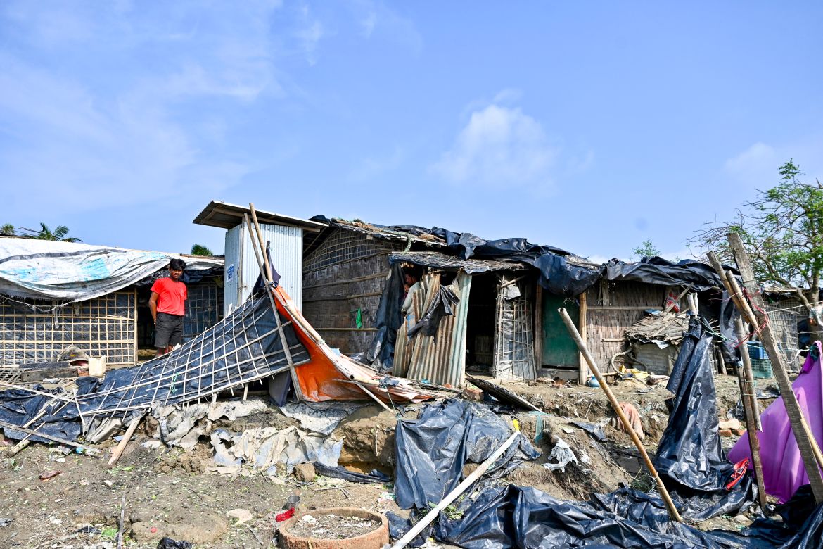 A man stands beside a house which was destroyed by cyclone Mocha, in Shahpori island on the outskirts of Teknaf