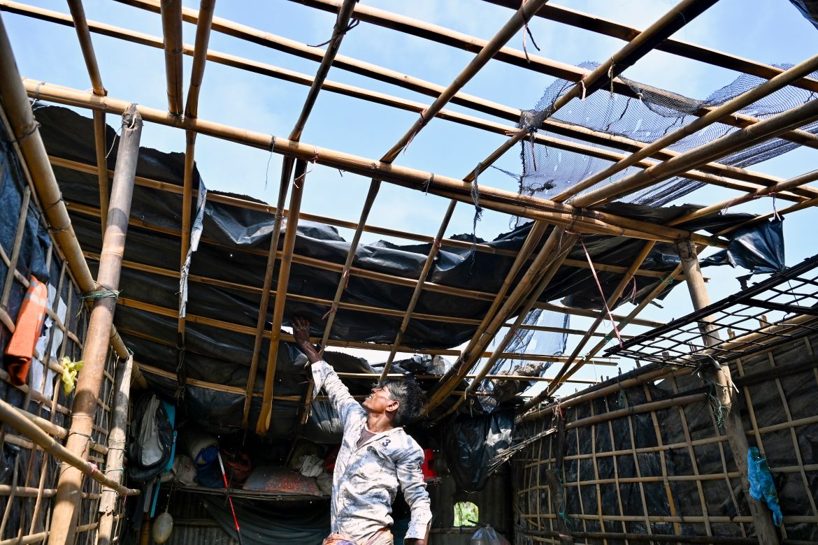 A man fixes his house's roof which was destroyed by cyclone Mocha, in Shahpori island on the outskirts of Teknaf