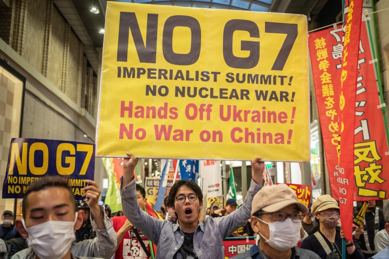 A group of activists take part in a protest against the G7 Leaders' Summit in Hiroshima on May 17, 2023, holding placards that say, "No G7! Imperialist summit! No nuclear war! Hands off Ukraine! No war on China!" [Yuichi Yamazaki/AFP]