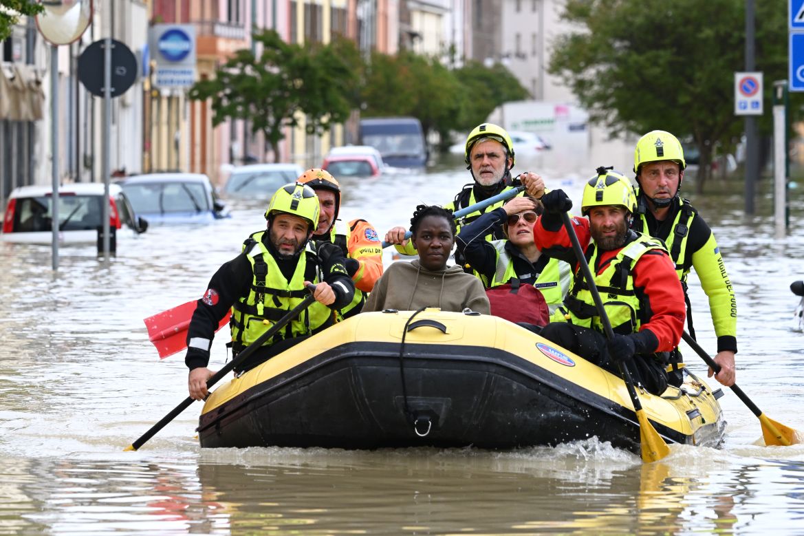 Rescuers transport residents in a dinghy across a flooded street in the town of Lugo, after heavy rains caused flooding across Italy's northern Emilia Romagna region, killing nine people. [Andreas Solaro/AFP]