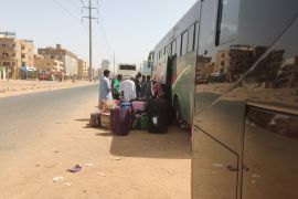 People load luggage into a bus in southern Khartoum as they prepare to leave the Sudanese capital to safer areas