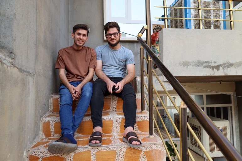 A photo of brothers Mumen and Ahmed sitting on the top of an outdoor staircase.