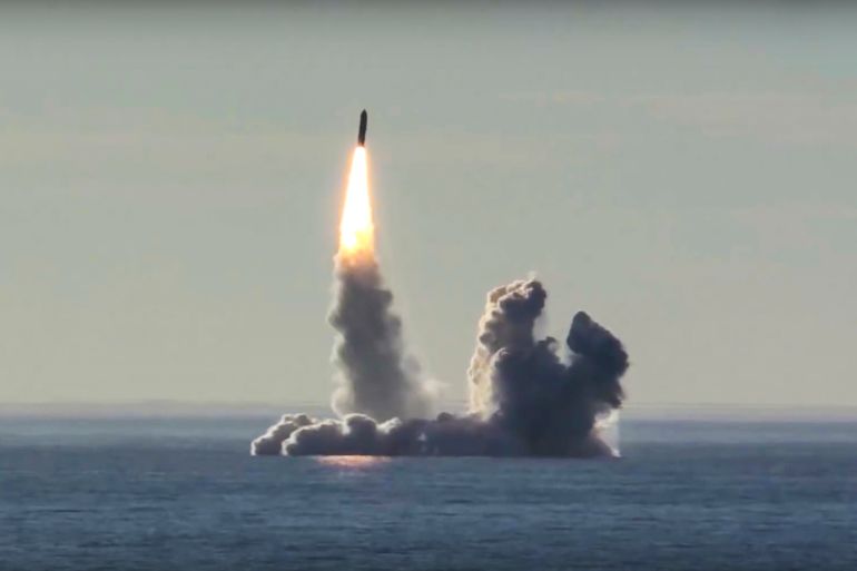 A bulava missile being tested from a Russian submarine. It is rising vertically leaving clouds of black smoke