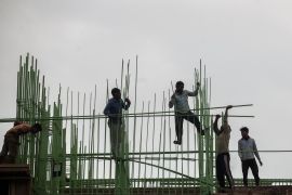 Laborers work at a building construction site in Mumbai, India