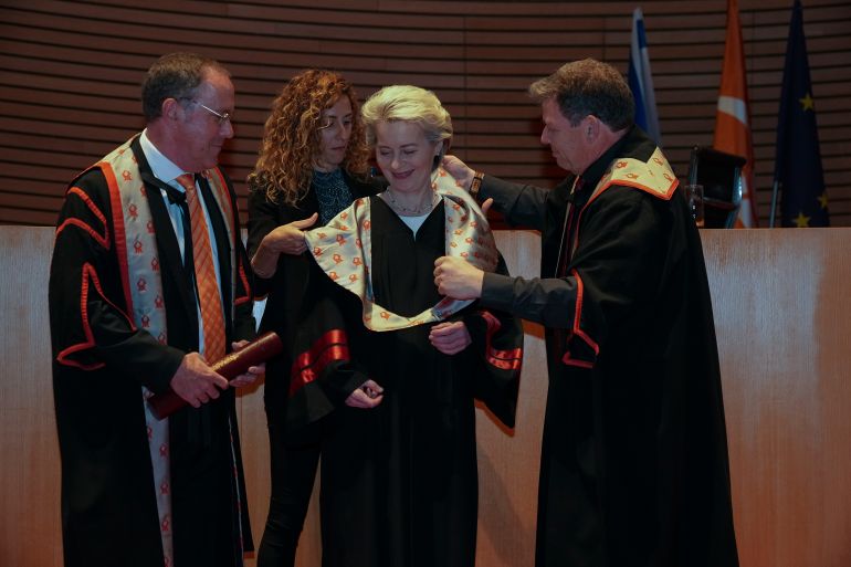 EU Commission President Ursula von der Leyen, center, receives an honorary doctorate from Ben-Gurion University of the Negev by the university president Daniel Chamovitz, left, and professor Chaim Hames, right, in Beersheba, southern Israel, Tuesday, June 14, 2022. The university gave von der Leyen the award in recognition of what it said was her statesmanship, fight against antisemitism and her commitment to enhancing ties with Israel. (AP Photo/Tsafrir Abayov)