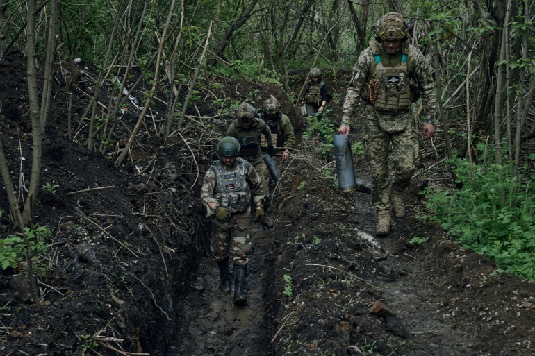 Ukrainian soldiers walk in a trench near Bakhmut, an eastern city where fierce battles against Russian forces have been taking place, in the Donetsk region, Ukraine.