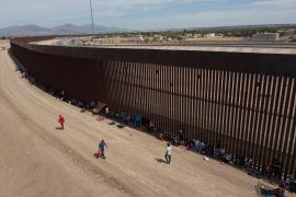 Asylum seekers camp out next to the border wall between the US and Mexico