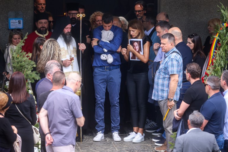 Parents of Ema Kobiljski, 13, mourn during the funeral procession at the central cemetery in Belgrade, Serbia, Saturday, May 6, 2023. Her schoolmate, a 13-year-old boy, on Wednesday, used his father's guns to kill eight fellow students and a guard. (AP Photo/Armin Durgut)