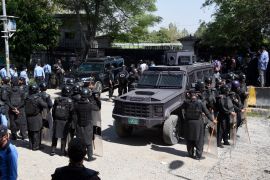 Pakistan's riot police officers stand guard with an armored vehicle outside a court, where Pakistan's former Prime Minister Imran Khan appearing, in Islamabad