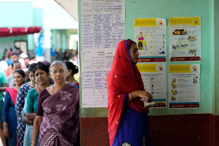 Women wait in a queue to caste their votes at a polling station in Bengaluru, India