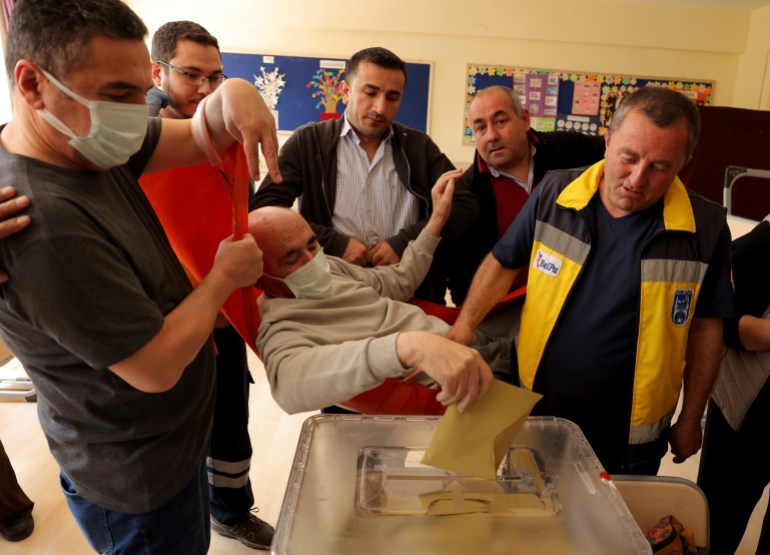 Cevat Cinar on a stretcher casts his ballot at a polling station in Ankara,