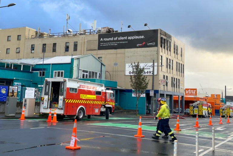 Firefighters work near a hostel in central Wellington, New Zealand