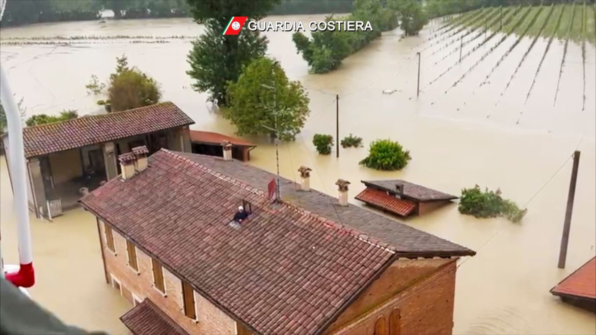 This photo provided by the Italian Coast guard shows a man on the roof of a flooded house just before being rescued by helicopter, in the area of the town of Faenza in the northern Italian region of Emilia Romagna, Wednesday, May 17, 2023 [Guardia Costiera via AP]