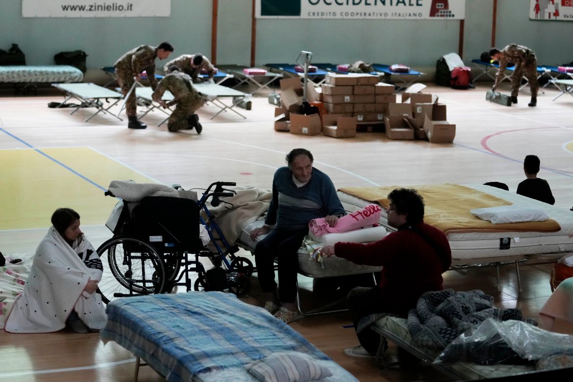 People rest in a makeshift camp set up inside the gymnasium of the flooded town of Castel Bolognese, Italy, Thursday, May 18, 2023 Luca Bruno/AP]