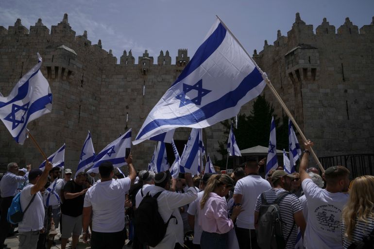 Israelis wave national flags ahead of a march marking Jerusalem Day