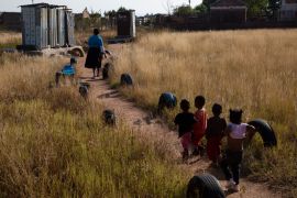 Children follow school manager towards pit toilets at a school in a village of Ga-Mashashane, South Africa